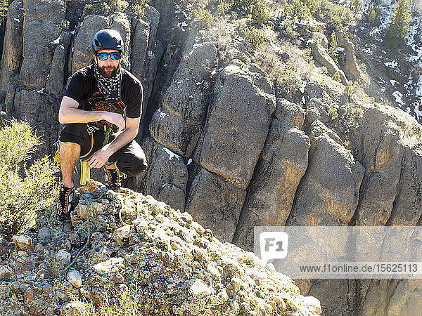 Ein Mann erklimmt den Heart Rock  einen Berg im Maple Canyon  und füllt das Gipfelbuch aus  das auf dem Gipfel aufbewahrt wird.