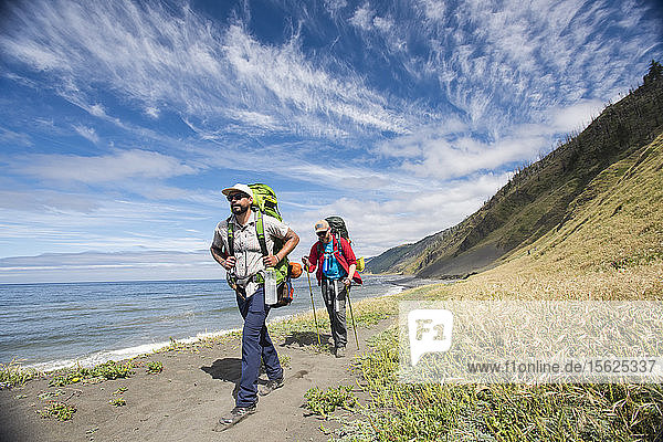 Two backpacker hiking in sandy shoreline of the Lost Coast