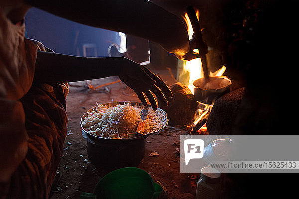 Ester Hodari  22 Jahre alt  kocht das Abendessen mit einem traditionellen Kocher mit drei Steinen und einem Feuer in der Mitte. Diese Kocher verbrauchen viel Brennstoff  Brennholz  und erzeugen eine Menge Rauch. Ester erzählte uns  dass sich ihre Augen beim Kochen mit dieser Art von Herd rot färben und sie oft einen Reizhusten hat. Ihre Kinder im Alter von 5  2 und 3 Monaten sind oft bei ihr  wenn sie kocht. Auch ihre Schwägerin Shadya Jumanne  11 Jahre alt  hilft ihr beim Kochen. Vor nicht allzu langer Zeit bekam Ester??????s 3 Monate altes Kind Husten  der immer schlimmer wurde  so dass sie nachts mit dem Motorrad ins Krankenhaus gebracht wurde. Ester begann  sich große Sorgen zu machen. Daraufhin beschlossen Ester und ihr Mann  einen sauberen Herd zu kaufen  und begannen zu sparen. Das Mädchen  das Ester auf einigen der Bilder beim Kochen hilft  ist ihre Schwägerin Shadya Jumanne  11 Jahre alt. Ester lernte die Unternehmerin Fatma Mziray von Solar Sister kennen  als sie ihren Mann heiratete und in dieses Dorf  Mforo bei Moshi  Tansania  zog. Ester sagte  dass Fatma für sie wie eine Mutter im Dorf ist. Als Fatma Ester den neuen Holzofen zeigte  sah sie  dass er weniger Holz verbraucht und weniger Rauch erzeugt.