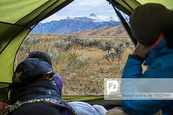 Campingpaar mit Blick auf die Berge außerhalb des Zeltes  Jackson  Wyoming  USA
