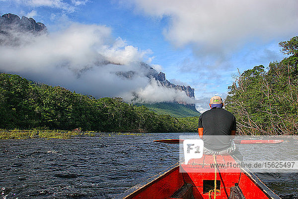 A dugout canoe carrying tourists speeds along the Canaima River towards Angel Falls  in Canaima National Park  Venezuela