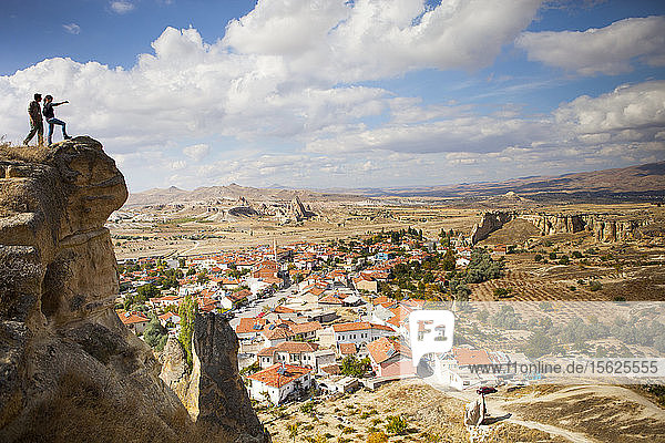 Zwei Wanderer blicken auf Cavusin  ein altes griechisches Dorf in Kappadokien in der Türkei. Es hat eine Kirche des heiligen Johannes aus dem 5. Jahrhundert und eine wunderbare Aussicht auf das Rosen- und das Rote Tal.