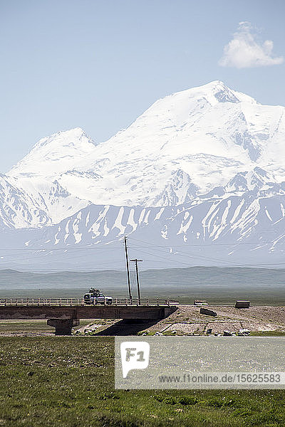 A car drives into the mountains of Pamir (Kyrgyzstan).