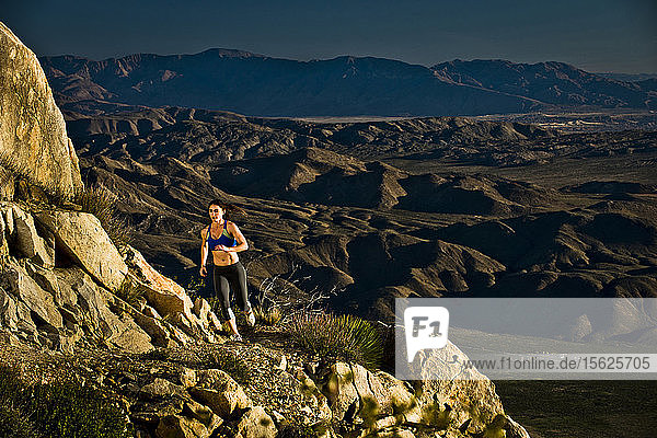 Ein Mädchen in Sportkleidung läuft einen felsigen Abschnitt des Pacific Crest Trail hinunter.