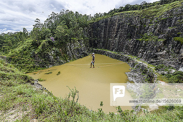 Abenteuerlustiger Mann beim Slacklinen über Wasser im Steinbruch Dibs  Maripora  Bundesstaat Sao Paulo  Brasilien