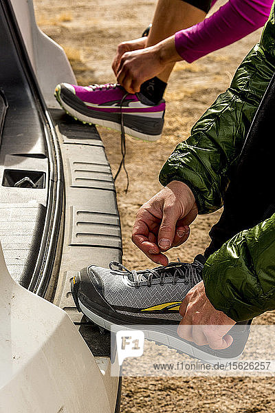 Man and woman putting on shoes for a trail run