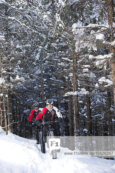 Rocky Mountain professional bikers during winter training session on Fat Bike in mountain trail of Quebec Canada