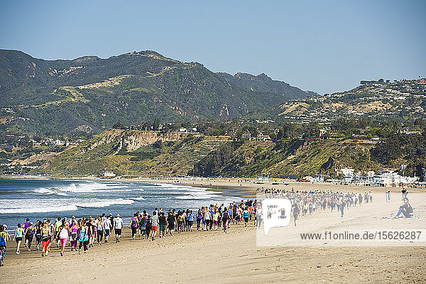 Large group of people running on beach in Santa Monica  California  USA