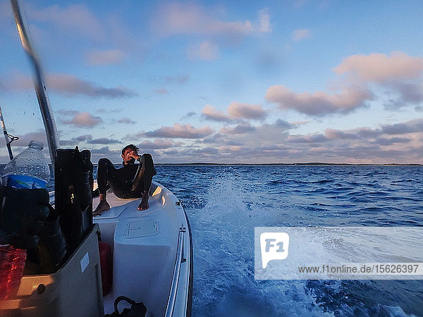 Taucher  der sich auf dem Bug des Bootes ausruht  während er von einem Ausflug zum Speerfischen und Freitauchen zurückkehrt  Clarence Town  Long Island  Bahamas