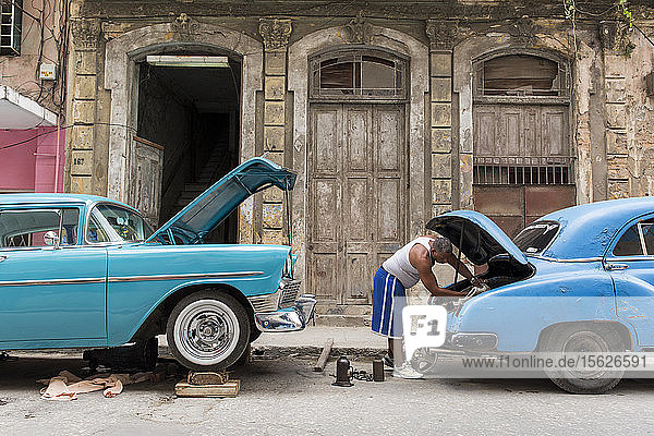 Mann repariert Auto auf der Straße in Havanna  Kuba