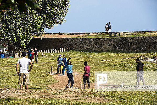 Boys playing cricket on grass  Galle  Sri Lanka