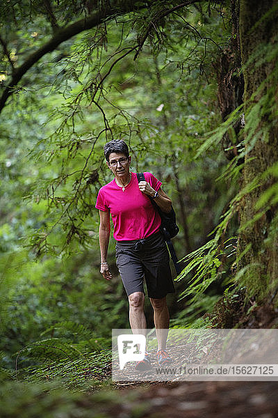 Front view of a female hiker on the trail in The Forest of Nisene Marks State Park. California  USA.