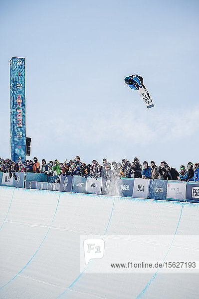 Sportler in der Luft beim Halfpipe-Snowboarding mit Zuschauermenge im Hintergrund  Vail  Colorado  USA