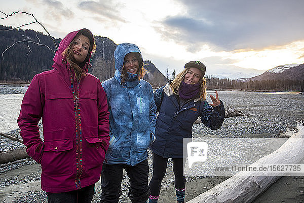 Die Profi-Snowboarder Robin Van Gyn  Helen Schettini und Jamie Anderson hängen nach einem Tag auf dem Snowboard in Haines  Alaska  am Ufer eines Flusses ab.
