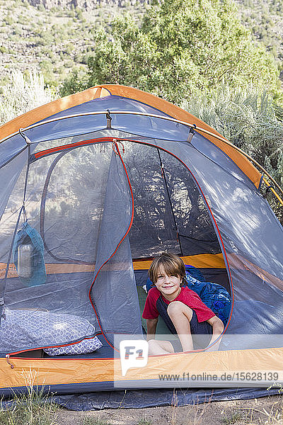 Porträt eines sechsjährigen Jungen  der in einem Zelt sitzt