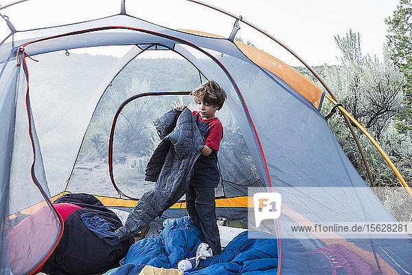 Sechsjähriger Junge zieht sich in seinem Zelt an
