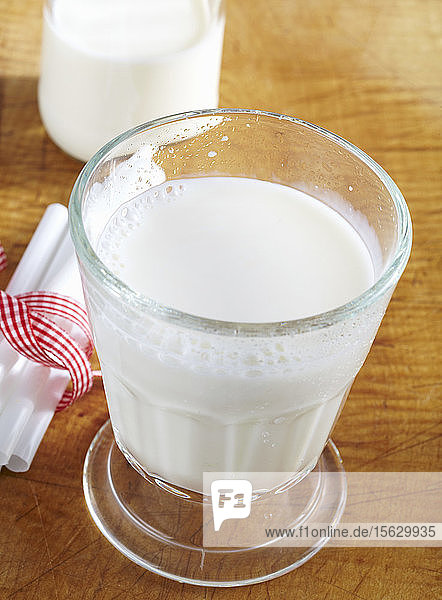 Kalte frische Milch im Glas auf Holzuntergrund