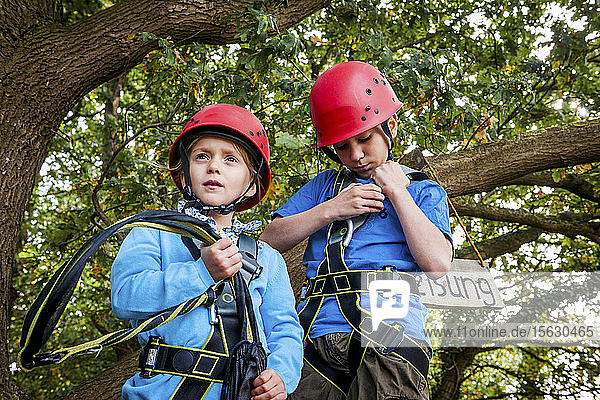 Boy and girl on a high rope course in forest