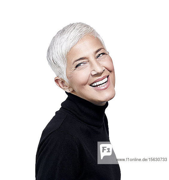 Porträt einer lachenden  reifen Frau mit kurzen  grauen Haaren und schwarzem Rollkragenpullover