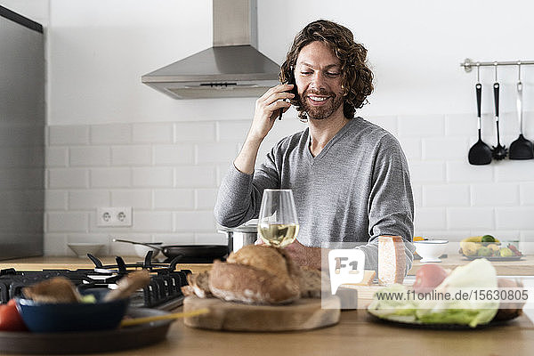 Mann am Telefon in der Küche zu Hause