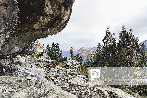 Hiker standing and looking over alpine plateau in autumn  Sondrio  Italy