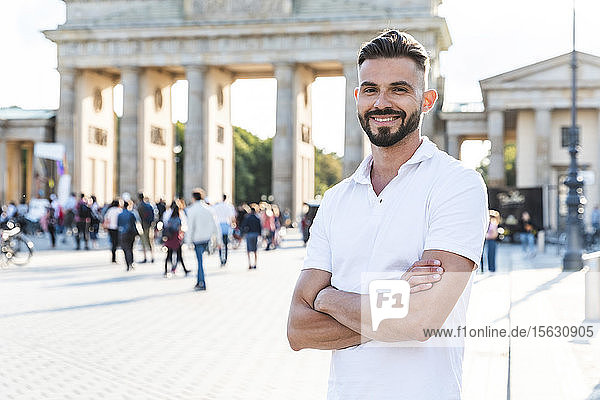 Porträt eines lächelnden jungen Mannes vor dem Brandenburger Tor  Berlin  Deutschland