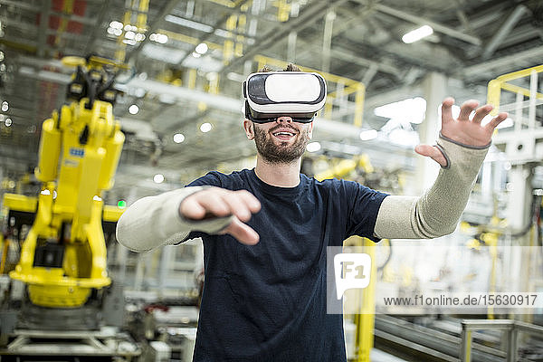 Mann mit VR-Brille in moderner Fabrik