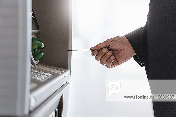 Nahaufnahme eines Geschäftsmannes  der Geld an einem Geldautomaten abhebt