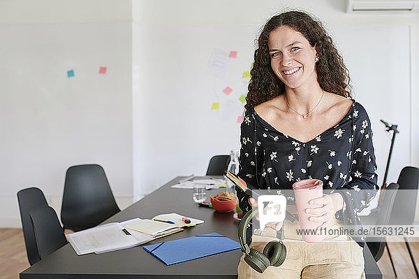 Porträt einer lächelnden lässigen jungen Geschäftsfrau in einem Büro