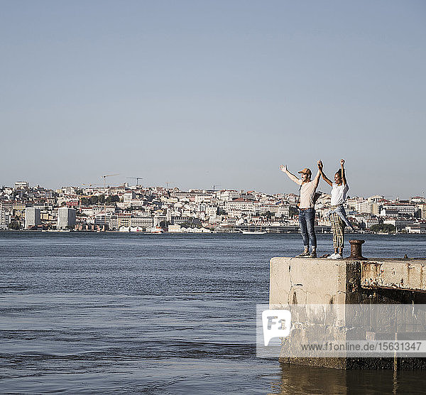 Glückliches junges Paar steht am Pier am Wasser  Lissabon  Portugal