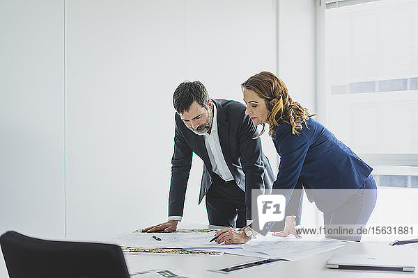 Geschäftsfrau und Geschäftsmann arbeiten am Plan auf dem Schreibtisch im Büro
