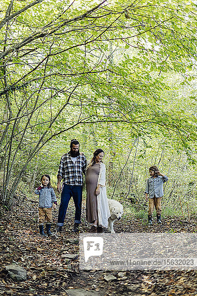 Family with two kids and dog in the forest