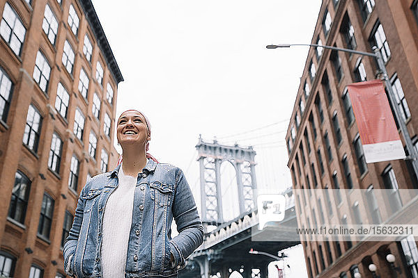 Lächelnde Frau mit Krebstuch an der Manhattan Bridge in New York  USA