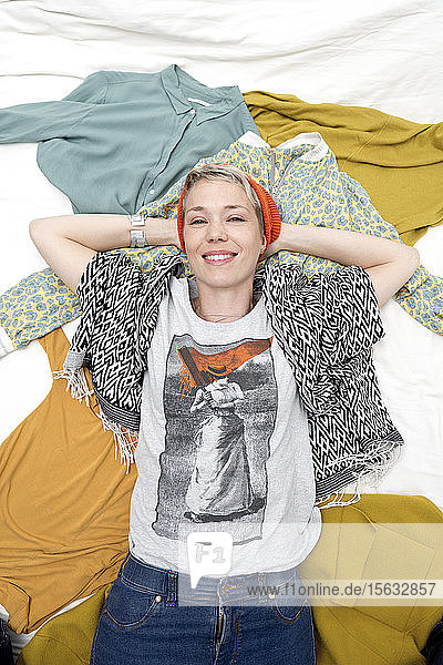 Portrait of stylish woman lying on clothing
