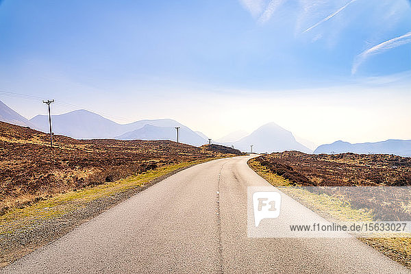 Verschwindende Sicht auf die leere Straße A863 mit den Cuillin-Bergen im Hintergrund  Isle of Skye  Highlands  Schottland  Großbritannien