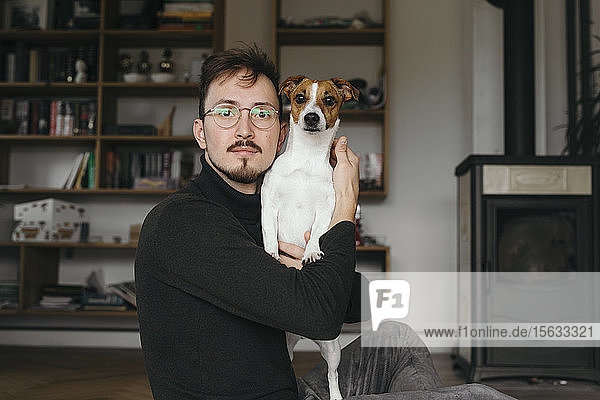 Young man with Jack Russel Terrier looking at camera