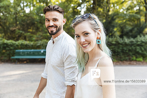 Portrait of happy young couple walking in a park