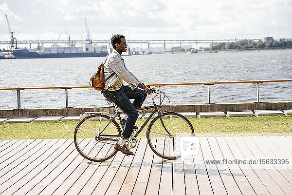 Young man riding bicycle at the sea