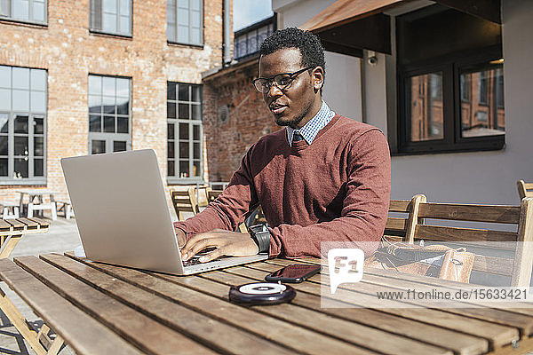 Junger Mann benutzt Laptop in einem Café