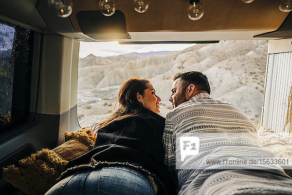 Junges Paar auf einer Reise  das bei Sonnenuntergang in einem Wohnmobil liegt  Almeria  Andalusien  Spanien