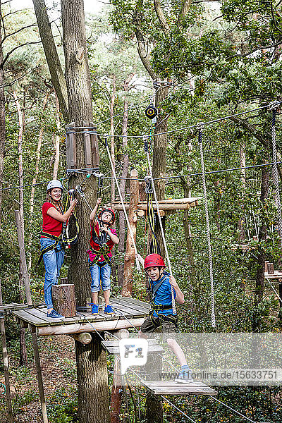 Family on a high rope course in forest