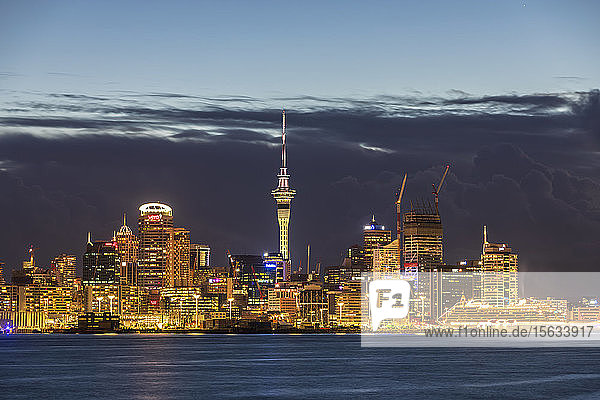 Beleuchtete moderne Gebäude am Meer gegen bewölkten Himmel in der Abenddämmerung in Ozeanien  Neuseeland