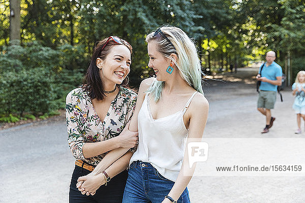 Two best friends strolling together in a park having fun