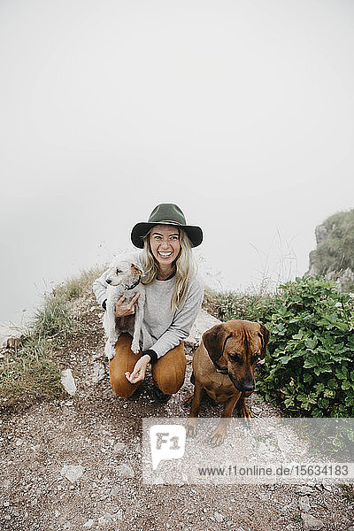 Junge Frau mit zwei Hunden auf dem Aussichtspunkt