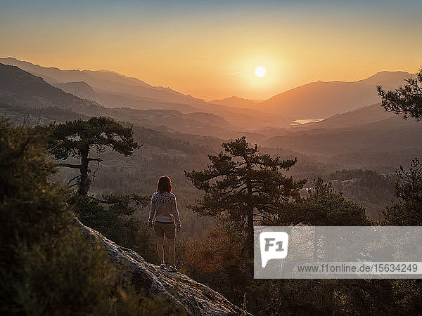 Female hiker standing on viewpoint  Albertacce  Lac de Calacuccia at sunrise  Haute-Corse  Corsica  France