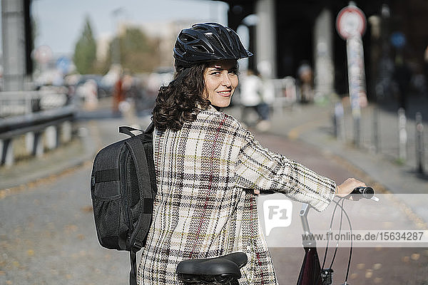 Portrait of woman with a bicycle in the city  Berlin  Germany