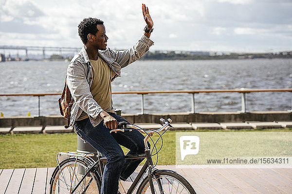 Junger Mann fährt Fahrrad am Meer