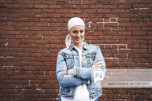 Frau mit Krebstuch vor einer Backsteinmauer in New York  USA
