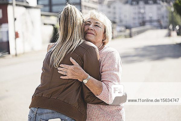 Enkelin umarmt ihre Großmutter