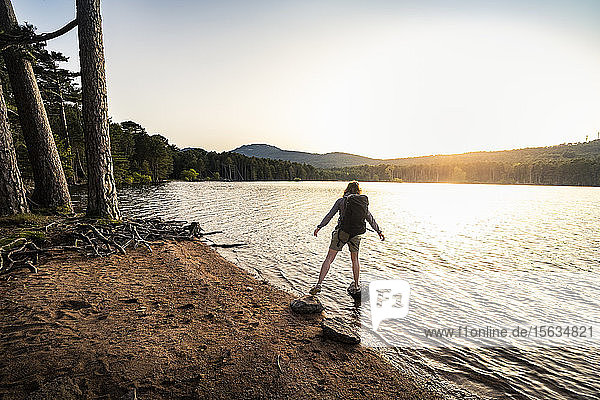 Rückansicht einer Wanderin  die einen Schritt macht  Reservoir de L'Ospedale am Morgen  Corse-du-Sud  Korsika  Frankreich